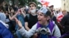 A demonstrator argues with police officers during an opposition protest against the "foreign agent" law outside the parliament building in Tbilisi on May 28. 