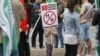 A young Romanian protester holds up an anti-LGBT sign at a rally ahead of the country's divisive upcoming referendum on the country's constitutional definition of marriage. 