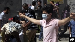 A protester flashes the "V" sign during clashes with Egyptian security forces in Cairo in late June.