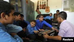 Visually impaired Afghan students play musical instruments during a music lesson at the Kabul Blind School.