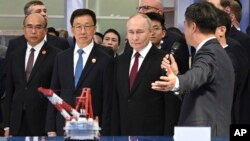 Russian President Vladimir Putin (center) and Chinese Vice President Han Zheng (second from left) visit the Russian-Chinese EXPO in Harbin, China, in May. 