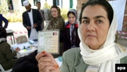 An Afghan woman shows her voter's pass for the August presidential election.