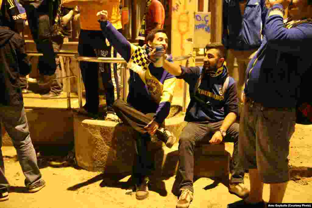 A group of Fenerbahce fans, all drinking Efes beer, mixes football songs with slogans against Turkish Prime Minister Recep Tayyip Erdogan.