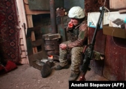 A Ukrainian serviceman smokes a cigarette in a dugout alongside his PK machine gun at a position in the Luhansk region of eastern Ukraine on January 22.