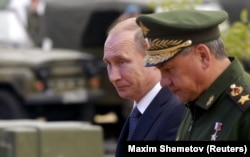 Russian President Vladimir Putin (left) and Defense Minister Sergei Shoigu arrive for the opening of a forum outside Moscow in June 2015.