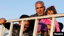 Newly arrived Syrian Kurdish refugees stand at the back of a truck after crossing into Turkey from the Syrian border town Kobani on October 6. 