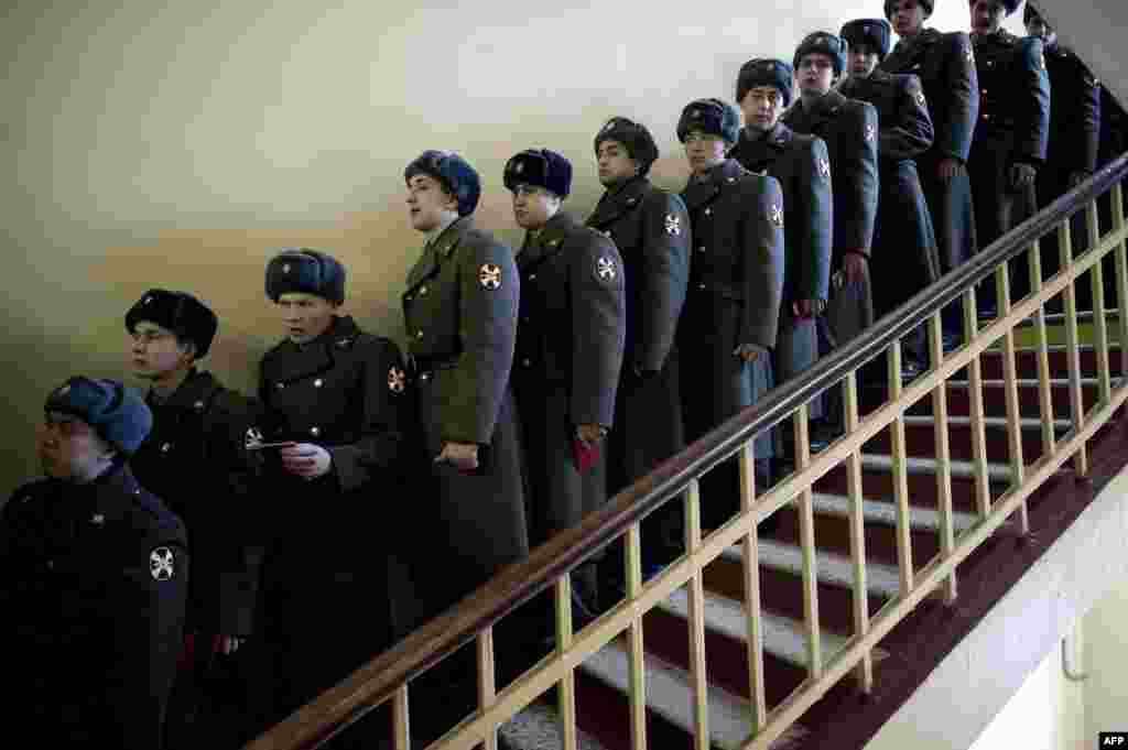 Russian soldiers stand in a queue at a polling station in Moscow.