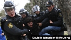 Police officers detain a man at a protest in Baku in January 2013.