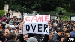 A Tunisian demonstrator hold a sign saying "Game Over" during a rally in front of the country's Interior Ministry in January.