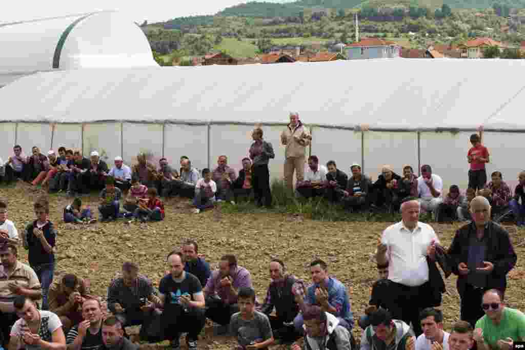 Ethnic Albanians pray during the funeral of one of the police officers, Isamedin Osmani, killed in a recent operation, in the village of Studenicani.