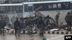 Indian security forces inspect the remains of a vehicle following a bomb attack in Kashmir on February 14.