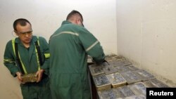 Workers stack gold bars in the safe at the Kumtor goldmine in Kyrgyzstan