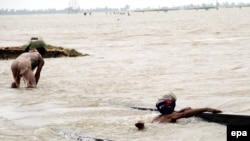 Pakistanis use a rail track as they flee flooded areas in Shikarpur in Sindh Province on August 25.