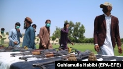 Former Taliban and other militants surrender their weapons during a reconciliation ceremony in Jalalabad on June 25.