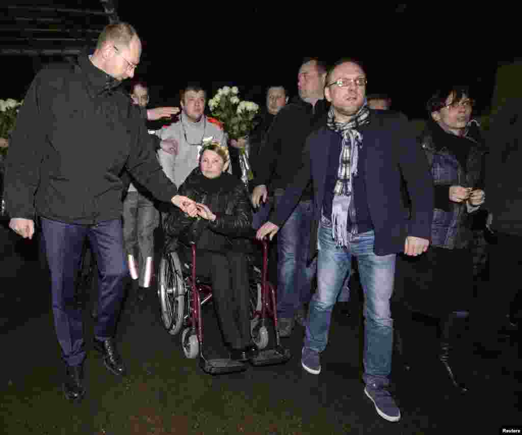 Tymoshenko holds the hand of her political ally, Arseniy Yatsenyuk, as she arrived at Kyiv's airport. 