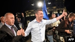 Ramush Haradinaj (left), leader of the Alliance for the Future of Kosovo (AAK), and Kadri Veseli (center), leader of the Democratic Party of Kosovo (PDK), of the "war wing" coalition celebrate their victory in Pristina on June 11.