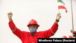 A worker of the Venezuelan state oil company Pdvsa holds an Iranian flag during the arrival of the Iranian tanker ship Fortune at the El Palito refinery in Puerto Cabello, Venezuela, on May 25.