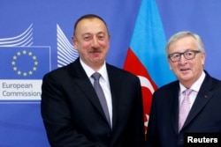 Azerbaijani President Ilham Aliyev (left) poses with European Commission President Jean-Claude Juncker ahead of a meeting at the EU Commission headquarters in Brussels on February 6.