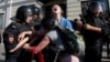 Police detain a young protester during an unsanctioned rally in Moscow on July 27. 