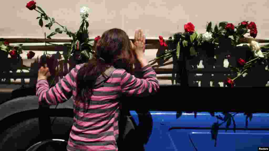 A woman kisses one of the three trucks carrying the coffins in front of the presidential building in Sarajevo on July 9.