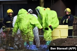 Officials in biohazard suits work near the bench in Salisbury where the Skripals were found.