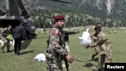 Pakistani military troops unload bags of grain from a U.S. Army helicopter delivering aid to the Khyber Pakhtunkhwa Province on August 5.