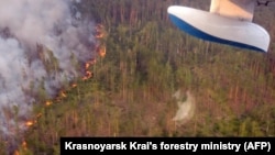 A picture taken from on board a firefighting aircraft shows a forest fire in the Krasnoyarsk Krai, Siberia, on July 30.