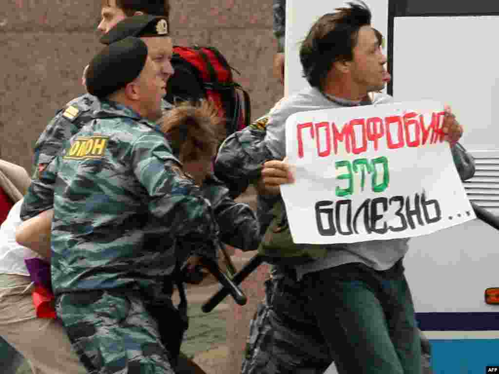 Police arrest a gay-rights activist as he holds a poster reading &quot;Homophobia Is A Disease&quot; during an unsanctioned gay-pride rally in St. Petersburg on June 25, 2011.