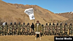 The Taliban assigned Tajik militant Muhammad Sharifov (center), who goes by the alias Mahdi Arsalon, to raise the Taliban flag at a strategic checkpoint near Afghanistan's border with Tajikistan last month.