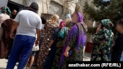 People line up outside a grocery in the Lebap region.