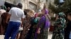 People wait in line for subsidized food at a state grocery in the Lebap region.