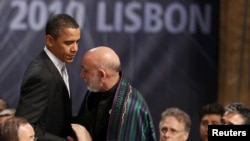 U.S. President Barack Obama (left) greets his Afghan counterpart, Hamid Karzai, before the opening session of the second day of the NATO Summit in Lisbon on November 20.