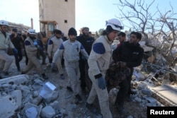 Rescue workers carry a dead body from a destroyed hospital supported by Medecins Sans Frontieres hit by missiles in Syria's Idlib Province on February 16.