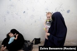 Zarima (right) from Chechnya, wife of a former Islamic State fighter, is pictured as she holds her daughter at a camp for displaced people in Ain Issa, north of Raqqa, Syria, in 2017.