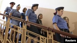 Pussy Riot members Nadezhda Tolokonnikova (left), Yekaterina Samutsevich (center), and Maria Alyokhina (right) are escorted by police to a court hearing in Moscow on August 8.