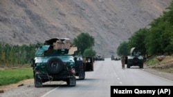 Afghan soldiers pause on a road at the front line of fighting between Taliban militants and Afghan security forces in the province of Badakhshan in northern Afghanistan on July 4.