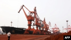 Bulldozers scoop soil containing various rare-earth elements to be loaded onto a ship at the port in Lianyungang, in China's eastern Jiangsu Province, for export to Japan.