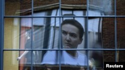 A banner with a portrait of Ukrainian military pilot Nadia Savchenko is reflected in a restaurant window in Tbilisi, Georgia.