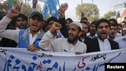 Student supporters of Jamaat-e Islami hold a banner and shout anti-American slogans in Peshawar on November 29 during a protest over the NATO air strikes three days earlier.