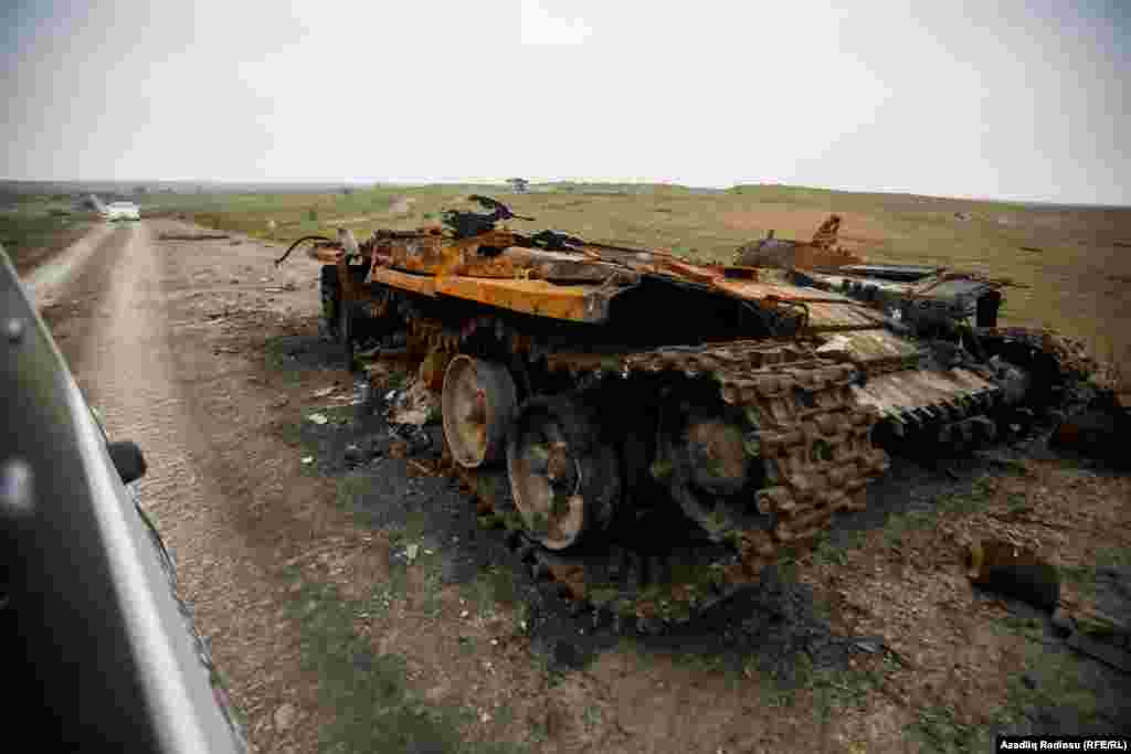 A destroyed Armenian tank stands at the side of a road in the Fuzuli district of Azerbaijan.