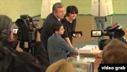 Georgian Prime Minister Giorgi Kvirikashvili, accompanied by his wife and son, votes in parliamentary elections in Tbilisi on October 8 (see video below).