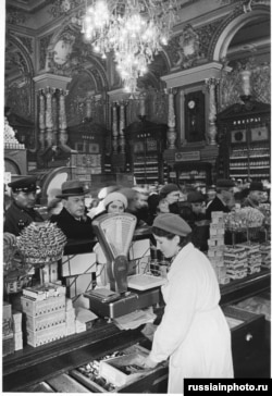 A clerk serves a crowd of customers in 1950.