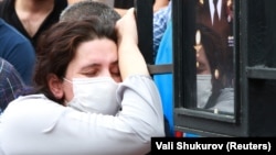 A woman grieves at the grave of Azerbaijani Armed Forces Major General Polad Hashimov, who was killed in armed clashes on the border between Azerbaijan and Armenia, during his funeral in Baku on July 15.