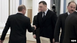 Putin (left) offers a hand to RusAl Chairman Deripaska (archive photo)