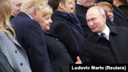 Russian President Vladimir Putin (right) greets German Chancellor Angela Merkel and U.S. President Donald Trump as they attend a commemoration ceremony for Armistice Day in Paris on November 11.