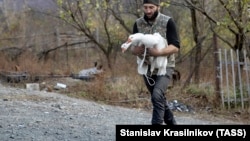 An ethnic Armenian man gathers farm animals as he prepares to leave his house in the village of Chorekdar.