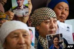 Petitioners with relatives missing or detained in Xinjiang hold up photos of their loved ones during a press event at the office of the Ata Jurt rights group in Almaty, Kazakhstan, on January 21.