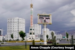 A giant thermometer on a roundabout in Ashgabat. The screen in the foreground played a loop of autocratic leader Gurbanguly Berdymukhammedov attending official ceremonies.