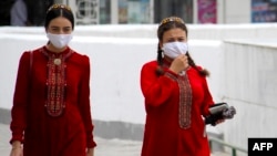 Turkmen women are seen wearing face masks in Ashgabat on July 13, where they had been banned just 2 week before.