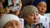 Petitioners with relatives missing or detained in Xinjiang hold up photos of their loved ones during a press event at the office of the Atazhurt rights group in Almaty, Kazakhstan, on January 21, 2019.